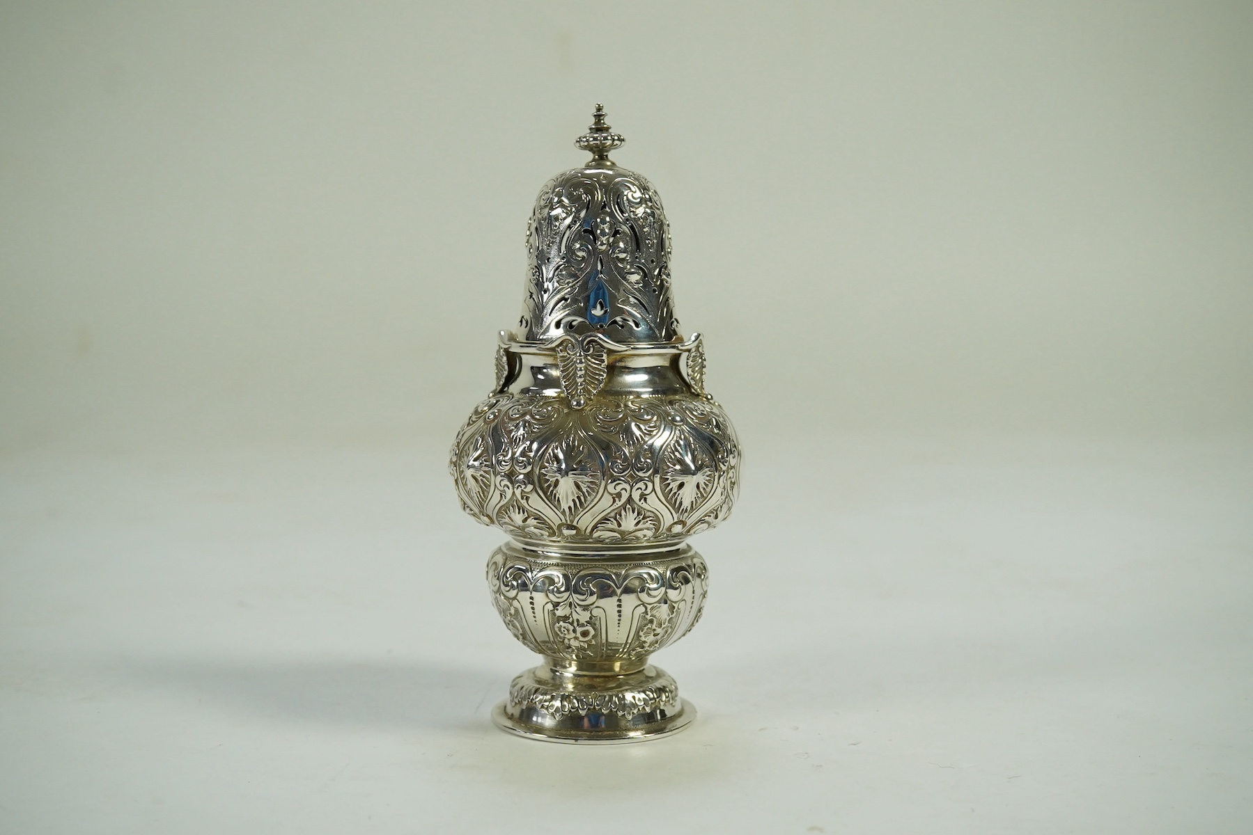 An ornate Edwardian silver sugar castor by Holland, Aldwinckle & Slater